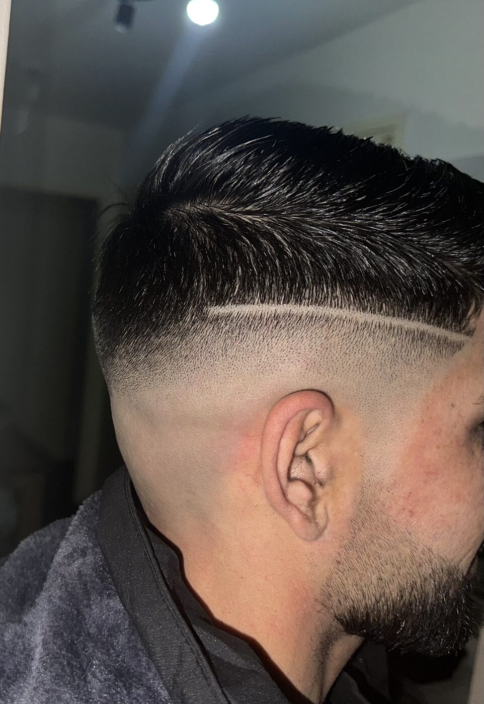 Skin fade met een strakke lijn in het haar